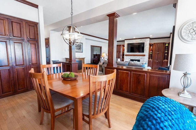 1516 E Orchard Beach Ln, Rice Lake, WI 54868 - dining area with a stone fireplace, light wood finished floors, a chandelier, decorative columns, and crown molding