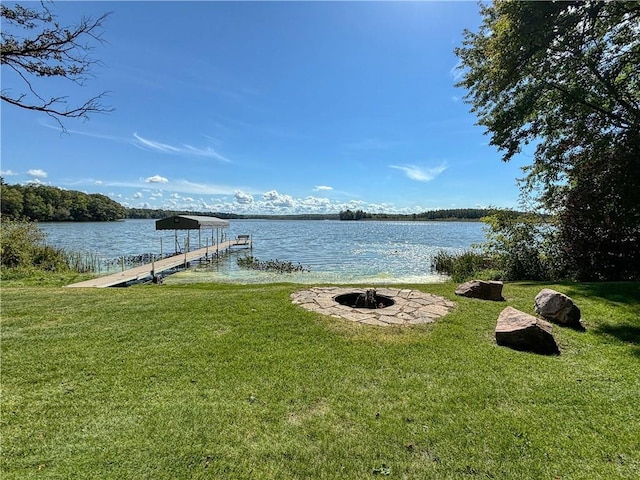 view of dock with a lawn, a water view, and an outdoor fire pit