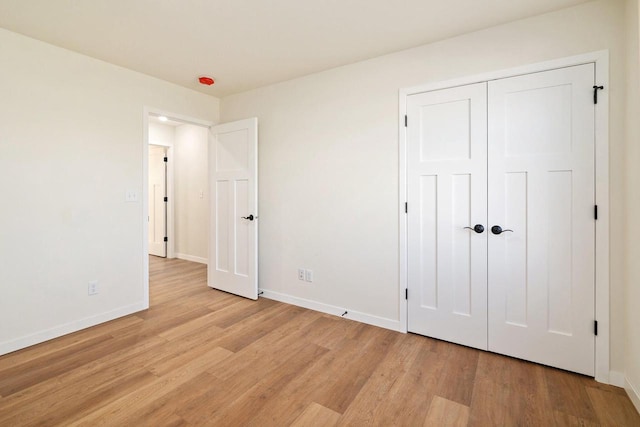 unfurnished bedroom with light hardwood / wood-style floors and a closet