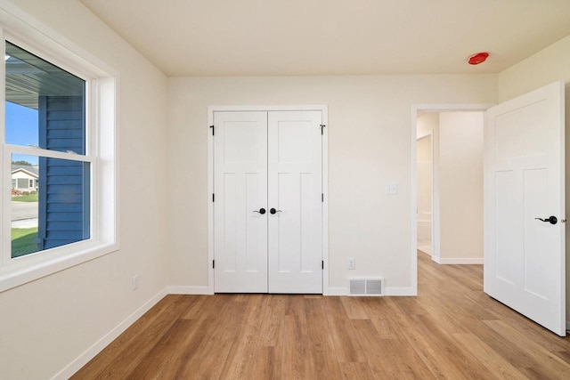 unfurnished bedroom with light hardwood / wood-style floors and a closet