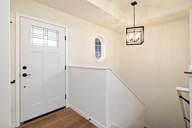 foyer entrance featuring hardwood / wood-style flooring and an inviting chandelier