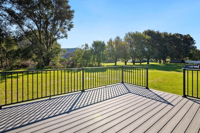 wooden deck featuring a lawn