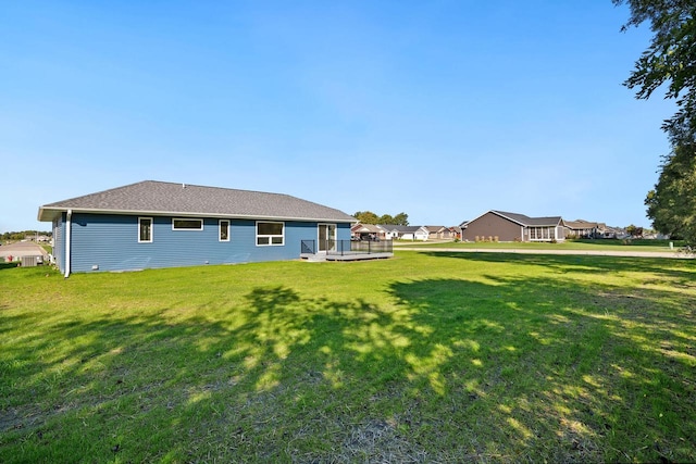 rear view of property featuring a lawn and a wooden deck