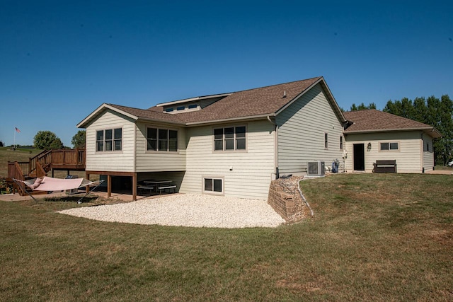 rear view of house with central AC unit, a wooden deck, and a lawn