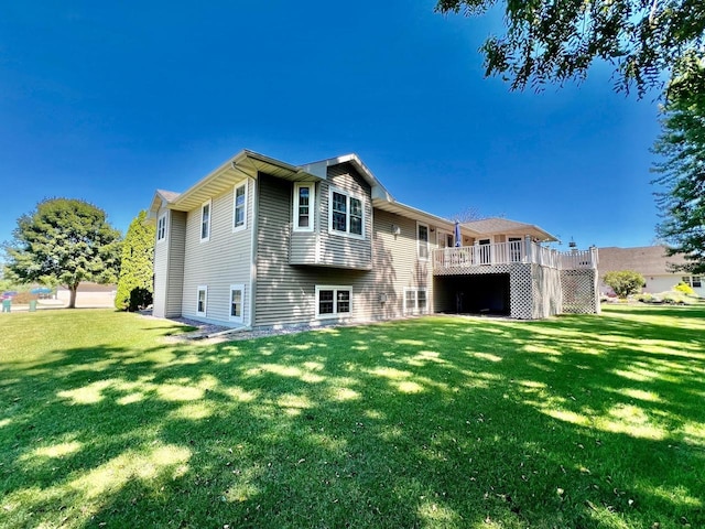 rear view of house featuring a deck and a yard