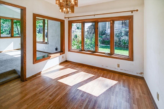 unfurnished room featuring light hardwood / wood-style floors and a notable chandelier