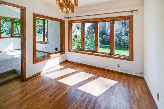 2809 Dewey Ct, Middleton, WI 53562 - empty room featuring baseboards, wood finished floors, and an inviting chandelier