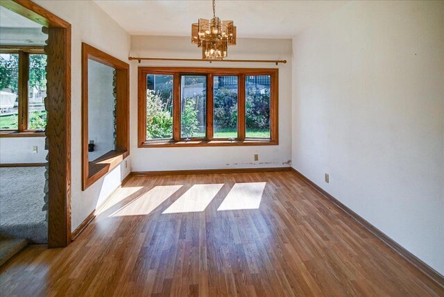 2809 Dewey Ct, Middleton, WI 53562 - spare room with baseboards, wood finished floors, and a chandelier