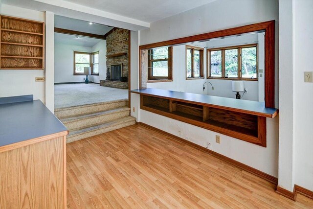 2809 Dewey Ct, Middleton, WI 53562 - kitchen with a stone fireplace, beam ceiling, baseboards, and wood finished floors
