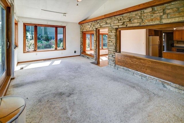 unfurnished living room featuring lofted ceiling and carpet flooring