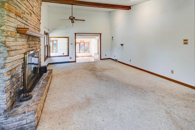 unfurnished living room featuring carpet floors, beamed ceiling, ceiling fan, and a brick fireplace