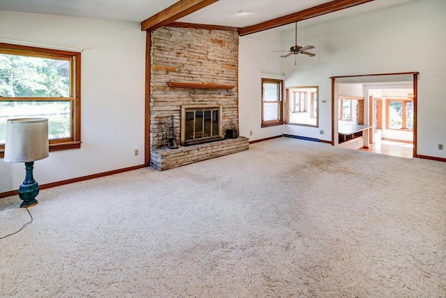 unfurnished living room with a stone fireplace, ceiling fan, and a wealth of natural light