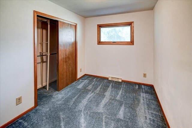 2809 Dewey Ct, Middleton, WI 53562 - unfurnished bedroom with dark carpet, baseboards, visible vents, and a closet