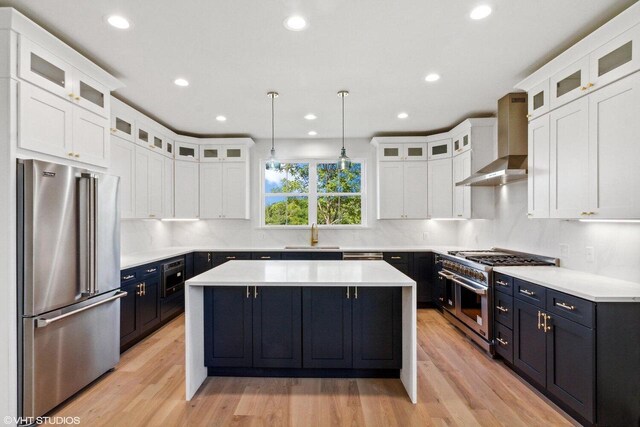 713 Greenview Cir Unit 55-35, Lake Geneva, WI 53147 - kitchen with light wood-type flooring, wall chimney exhaust hood, premium appliances, and pendant lighting