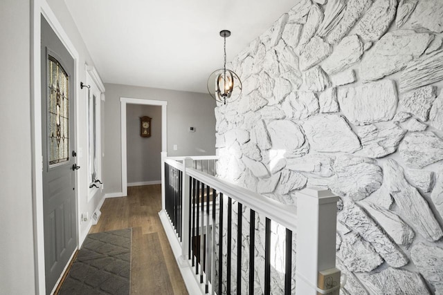 hallway featuring an inviting chandelier and dark hardwood / wood-style flooring