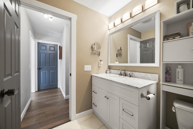 bathroom with hardwood / wood-style flooring, vanity, and toilet