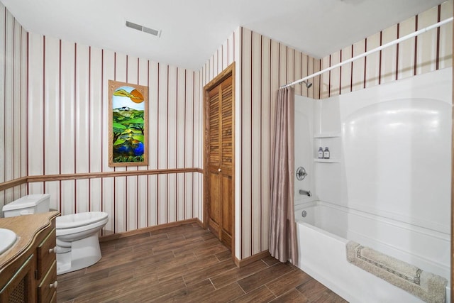 full bathroom with hardwood / wood-style floors, shower / bathtub combination with curtain, toilet, and vanity