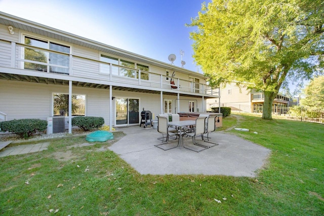 back of house featuring a balcony, a patio, central air condition unit, and a yard