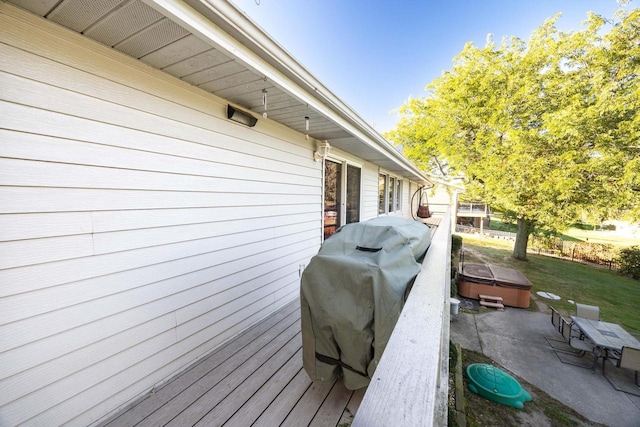 view of property exterior with a deck and a hot tub