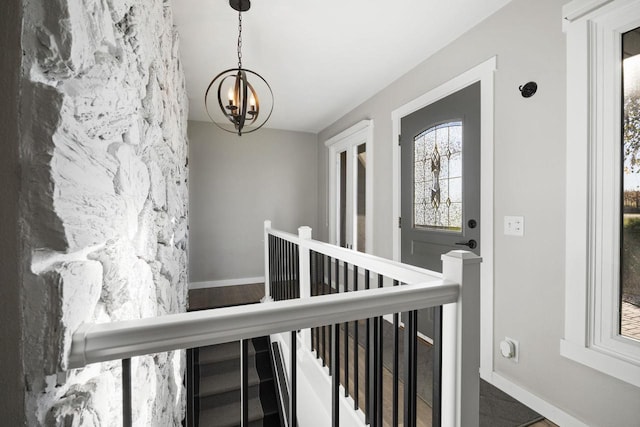 stairs with a notable chandelier