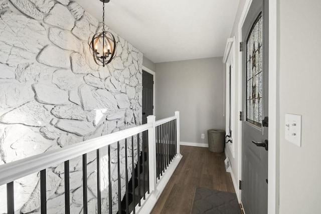 corridor featuring a chandelier and dark wood-type flooring