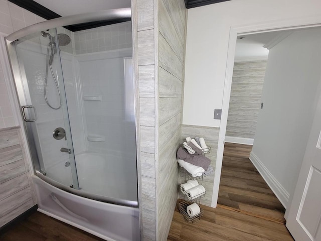 bathroom with tile walls, crown molding, combined bath / shower with glass door, and hardwood / wood-style flooring