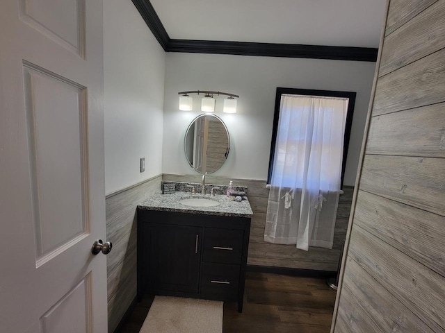 bathroom with vanity, ornamental molding, wood-type flooring, and tile walls