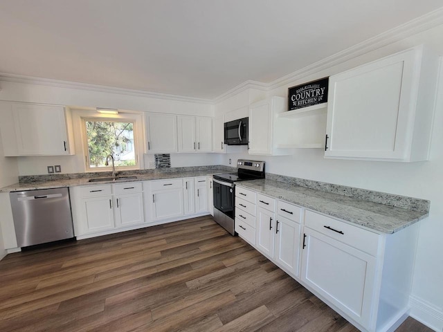 kitchen featuring appliances with stainless steel finishes, white cabinetry, and sink