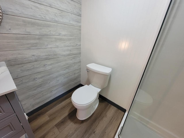 bathroom featuring vanity, toilet, a shower with door, and hardwood / wood-style floors