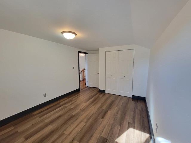 unfurnished bedroom featuring dark wood-type flooring and a closet