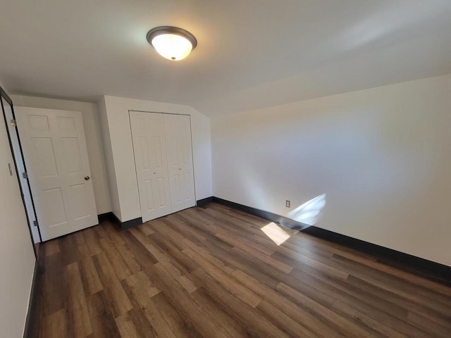 unfurnished bedroom with a closet and dark hardwood / wood-style floors