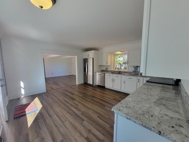 kitchen featuring dark hardwood / wood-style floors, stainless steel appliances, sink, light stone countertops, and white cabinets