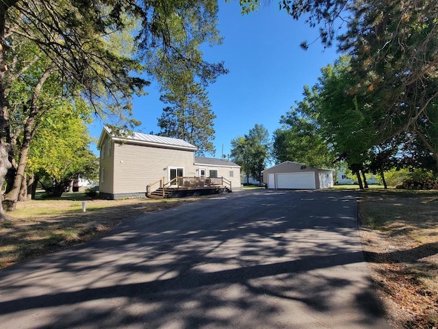 view of home's exterior with an outdoor structure, a deck, and a garage