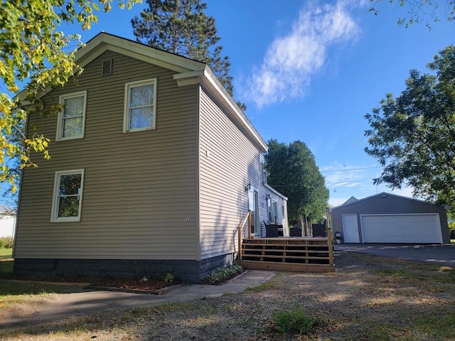 view of property exterior with a garage and an outbuilding