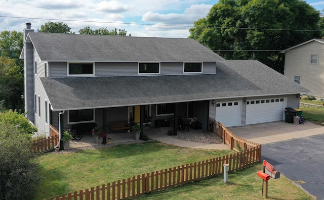 front of property featuring a patio, a garage, and a front lawn