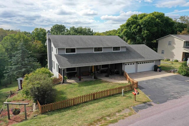 36997 Wildernest Rd, Prairie Du Chien, WI 53821 - view of front of property featuring aphalt driveway, an attached garage, a chimney, a fenced front yard, and a shingled roof