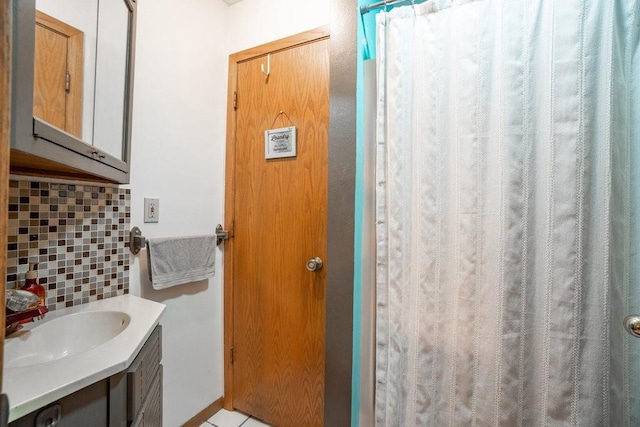 bathroom with decorative backsplash, walk in shower, and vanity