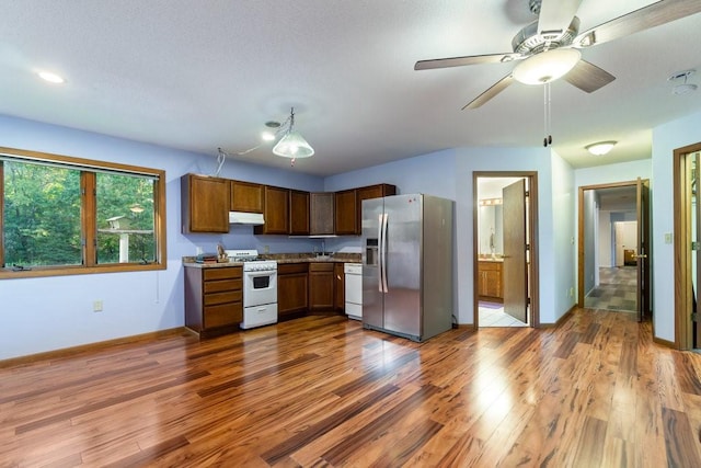 kitchen featuring white appliances, hardwood / wood-style floors, ceiling fan, and sink