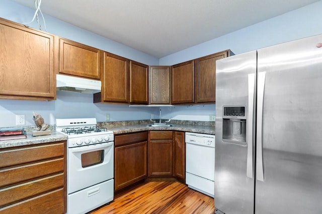 kitchen featuring light hardwood / wood-style flooring, sink, and white appliances