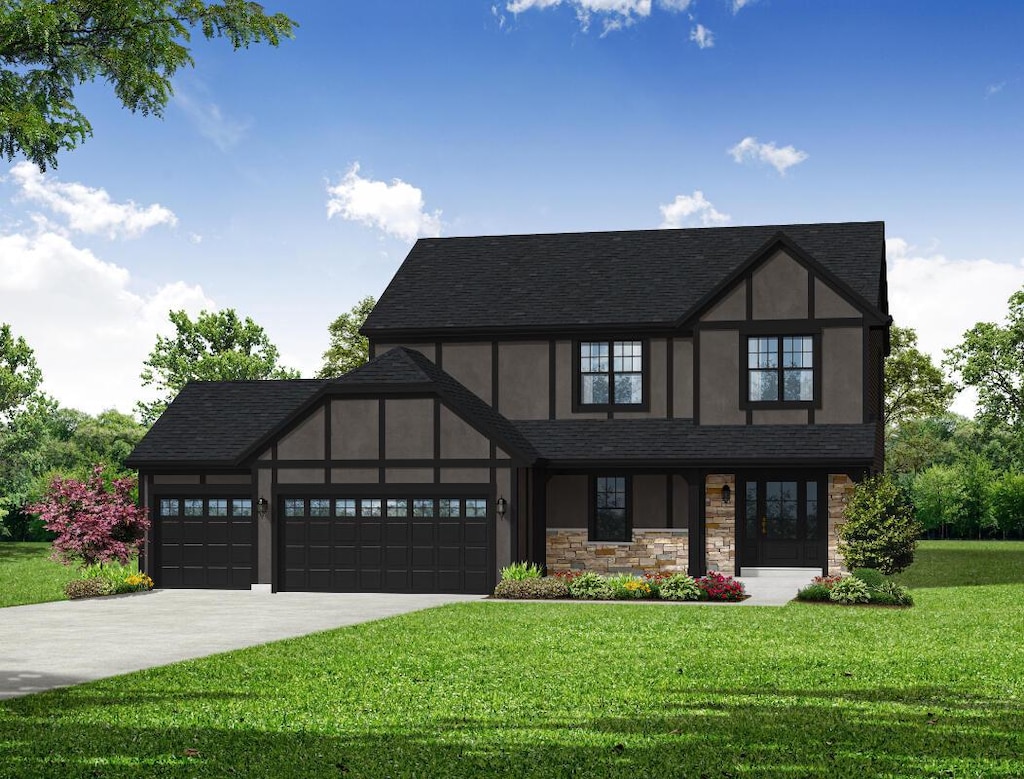 tudor-style house featuring a garage and a front lawn