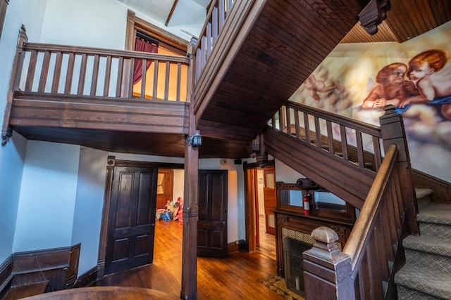 stairs featuring hardwood / wood-style flooring, wooden ceiling, and vaulted ceiling