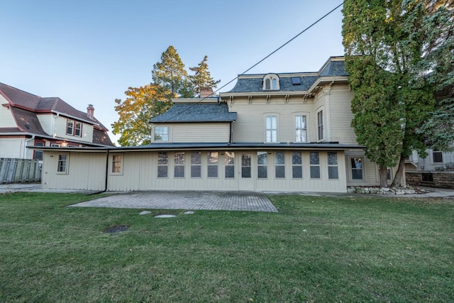 back of house with a yard and a patio