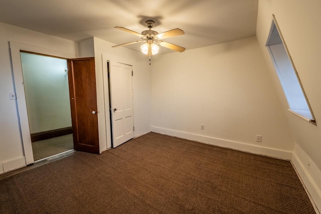 unfurnished bedroom with ceiling fan and dark carpet