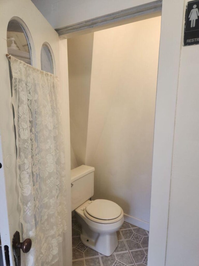 bathroom with toilet and tile patterned flooring