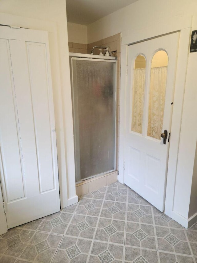 bathroom with tile patterned flooring and an enclosed shower