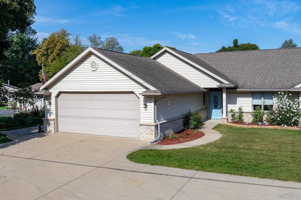 ranch-style house featuring a front lawn and a garage