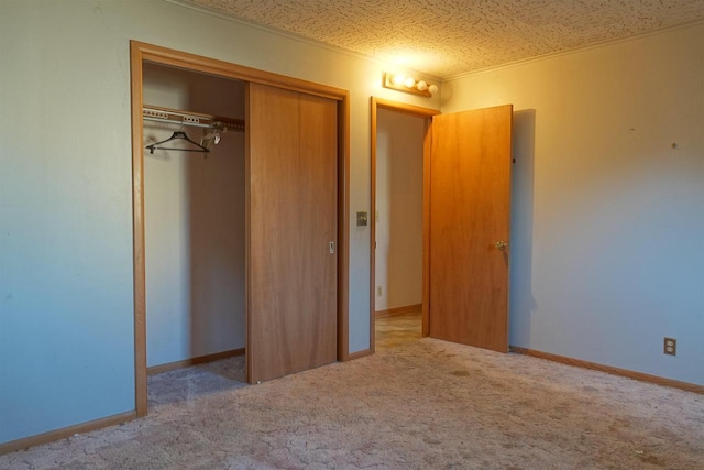 unfurnished bedroom with light colored carpet, a textured ceiling, and a closet