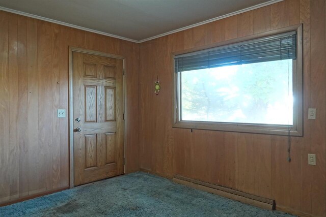 interior space featuring crown molding, wooden walls, light carpet, and a baseboard radiator