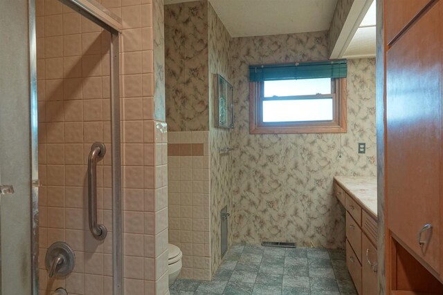 bathroom featuring vanity, toilet, and an enclosed shower