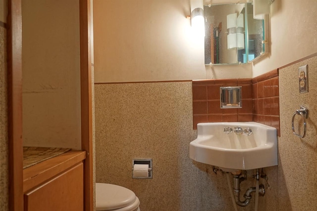 bathroom with tile walls and toilet